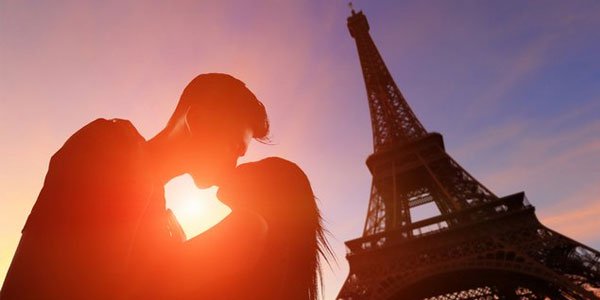 A couple kissing in front of Eiffel Tower in Paris