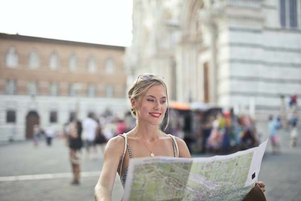 A woman holding a map looking for next destination